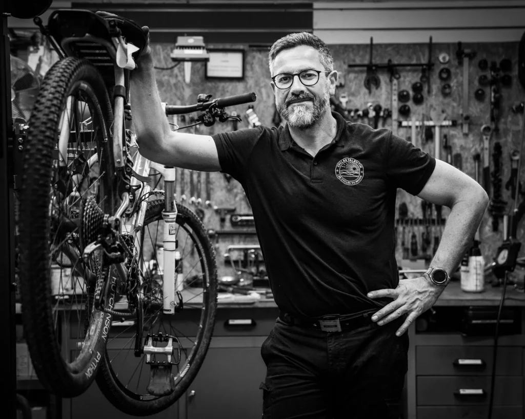 Reportage photo corporate en noir et blanc – mécanicien vélo dans son atelier, portrait professionnel réalisé à Arcachon par Art6Sens