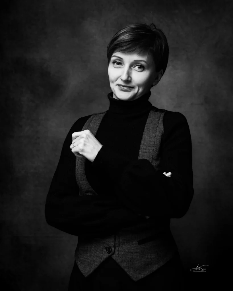 Portrait professionnel en noir et blanc d’une femme en col roulé, attitude sérieuse.