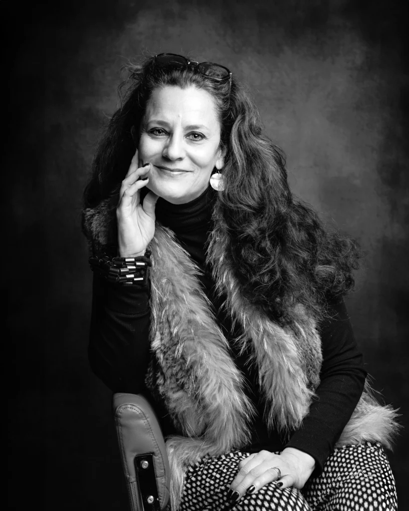 Portrait d’une femme en studio, vêtue d’un gilet en fourrure, photo corporate en noir et blanc.