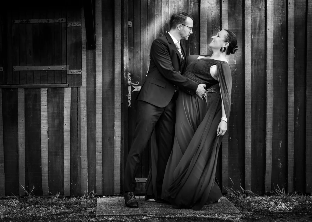 Portrait en noir et blanc d’un couple élégant en extérieur.