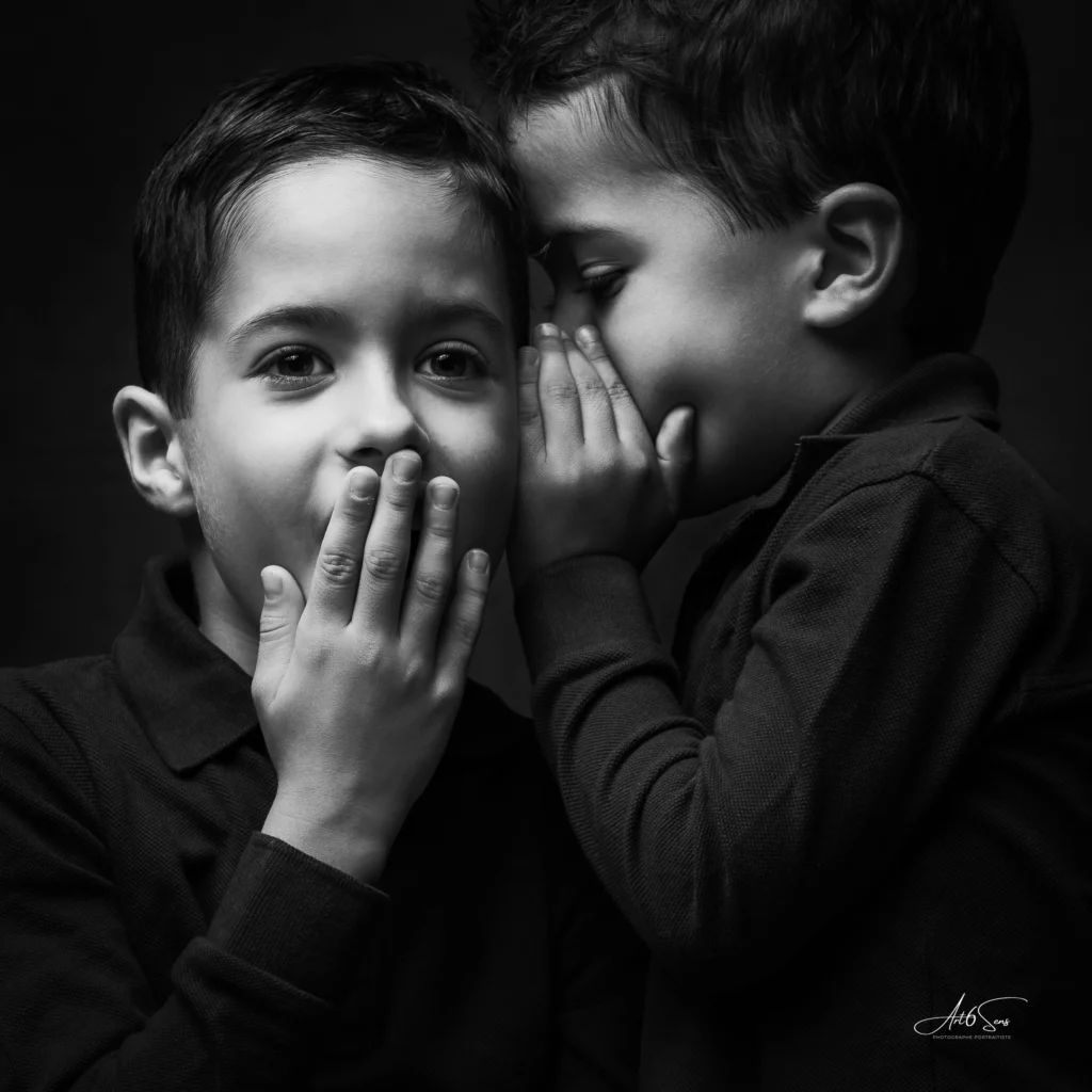 Portrait en noir et blanc de deux frères partageant un secret.