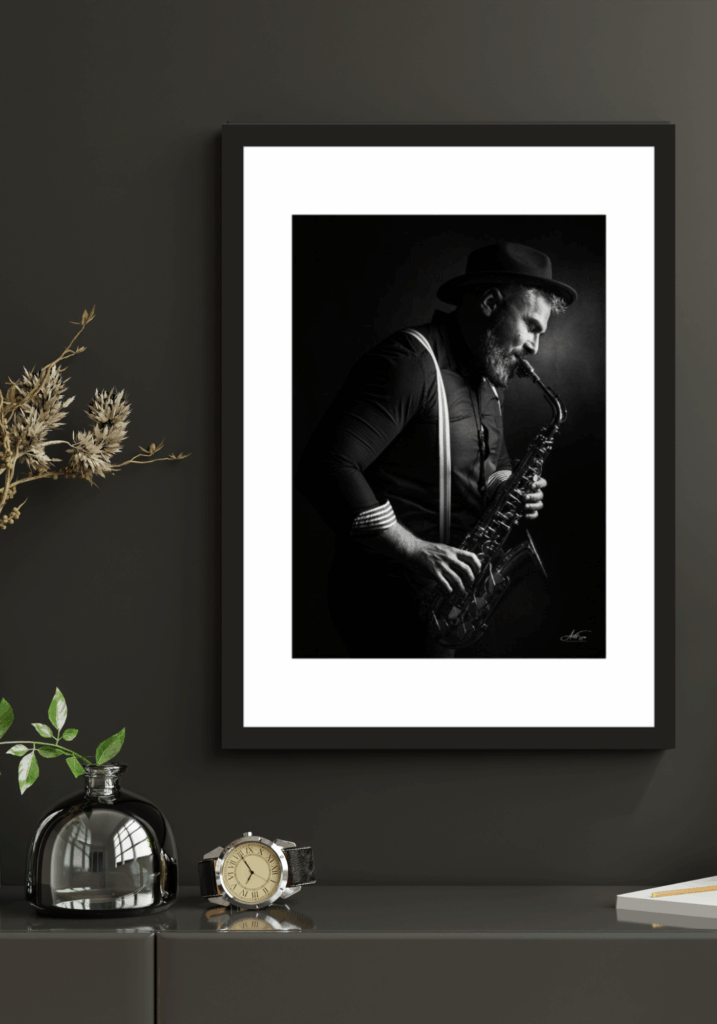 Tirage photo encadré d’un musicien jouant du saxophone, noir et blanc, format 21x30 cm sur papier Canon Satin, cadre noir avec passepartout, sans vitre, édition limitée