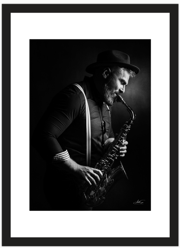 Tirage photo encadré d’un musicien jouant du saxophone, noir et blanc, format 21x30 cm sur papier Canon Satin, cadre noir avec passepartout, sans vitre, édition limitée