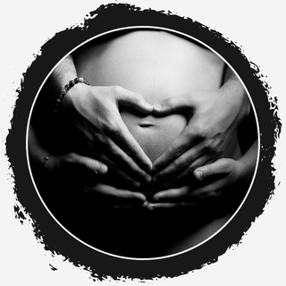 Photo en noir et blanc du d'une femme enceinte les mains sur le ventre en forme de coeur