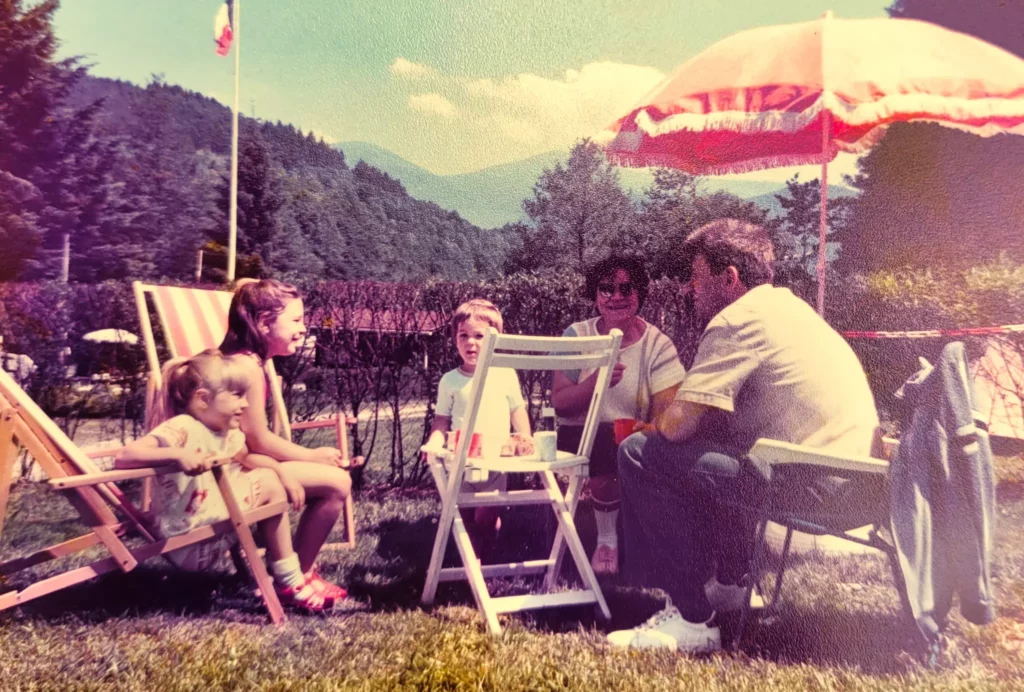 Photo de famille vintage au camping en Alsace, parents et enfants autour d'une table en plein air