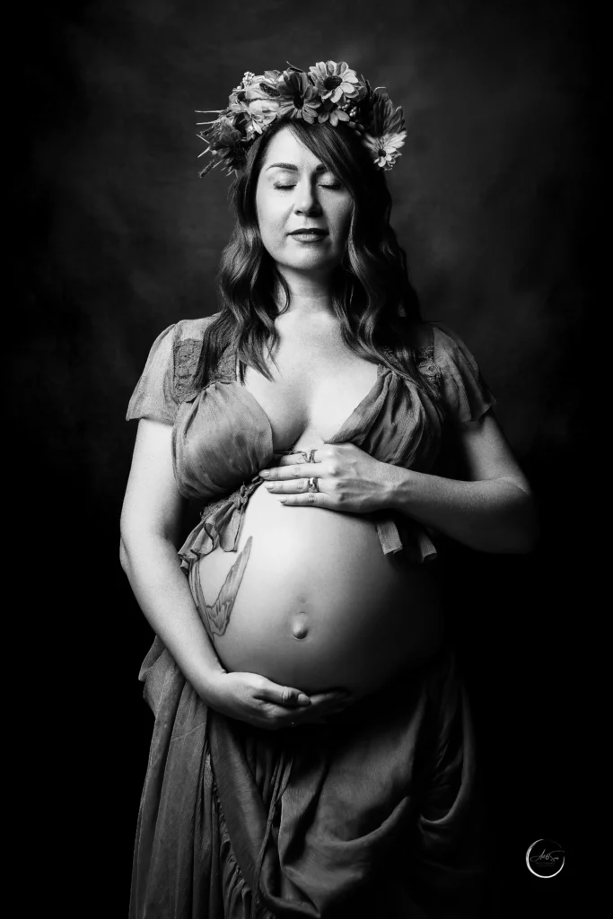 Portrait de grossesse en noir et blanc, femme enceinte couronnée de fleurs les yeux fermés, studio Art6sens Bassin d'Arcachon