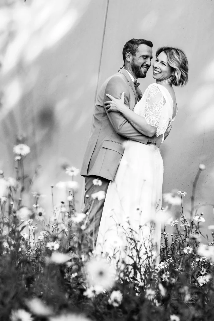 Portrait de mariage en noir et blanc, couple enlacé dans un champ de marguerites, Art6sens Bassin d'Arcachon